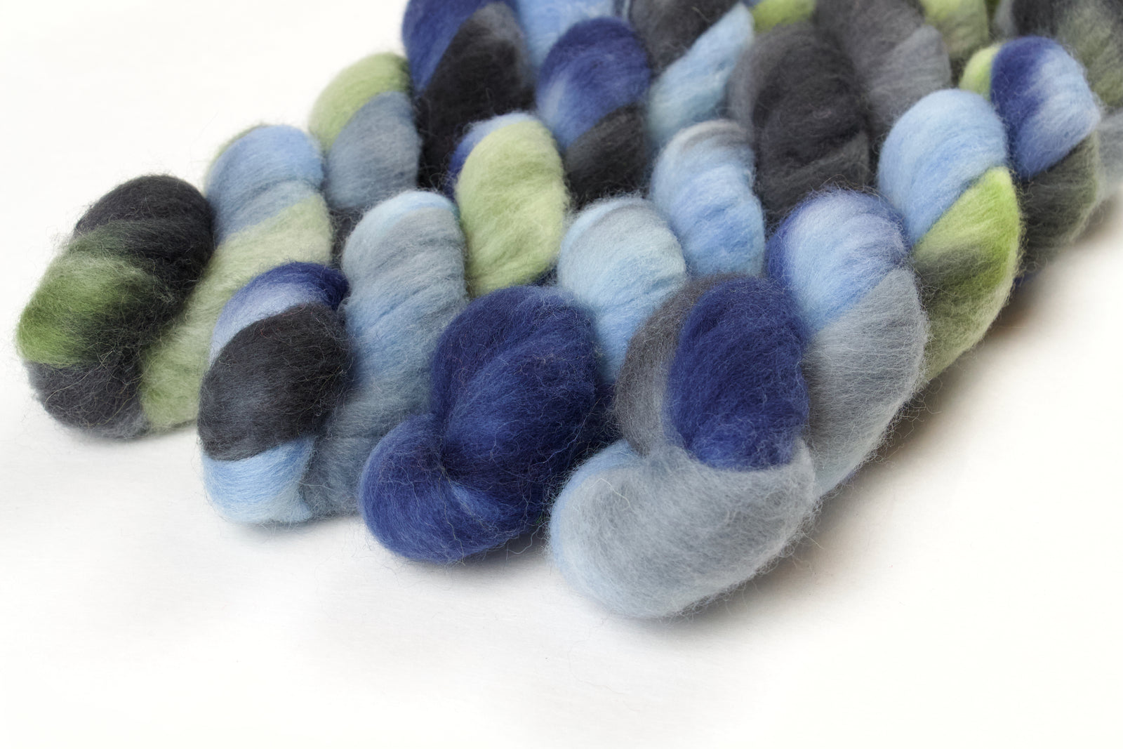 Braided fiber skein with blue, gray, and green on a white background