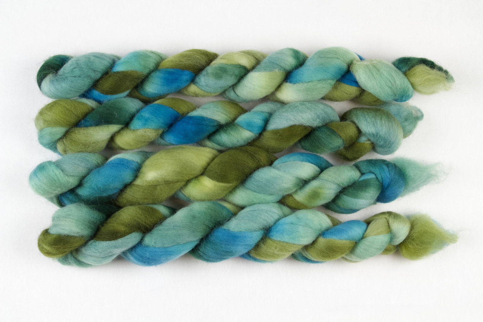 Braided fiber skein with green and blue gradient on a white background
