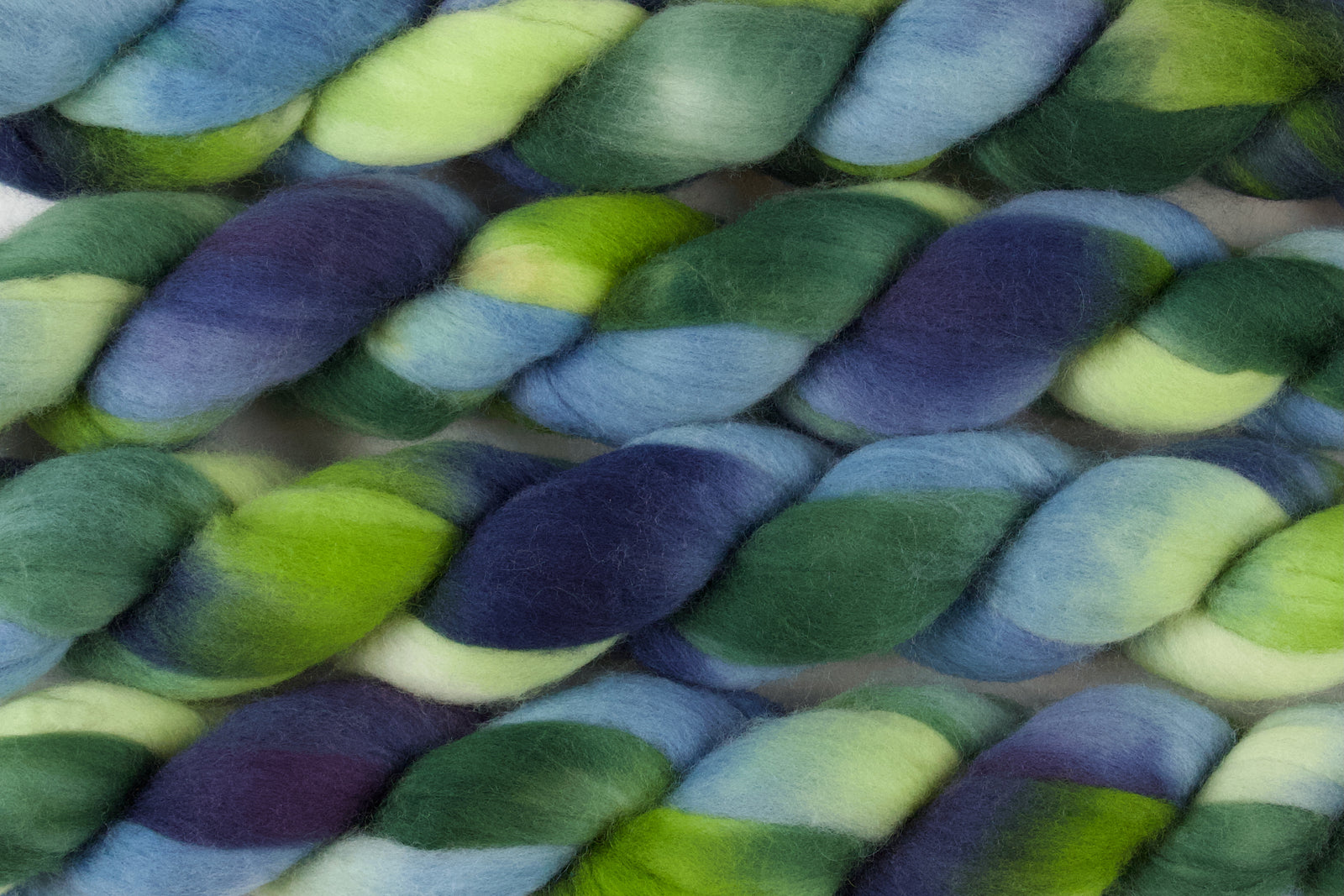 Braided fiber skein with green and blue on a white background