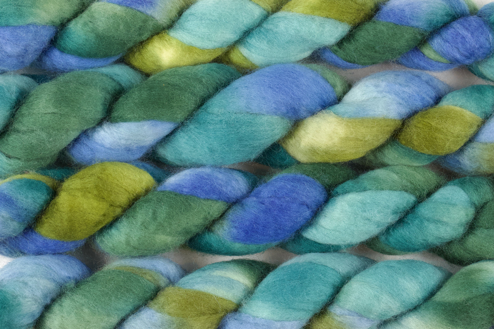 Braided fiber skein with blue, purple, and pink on a white background