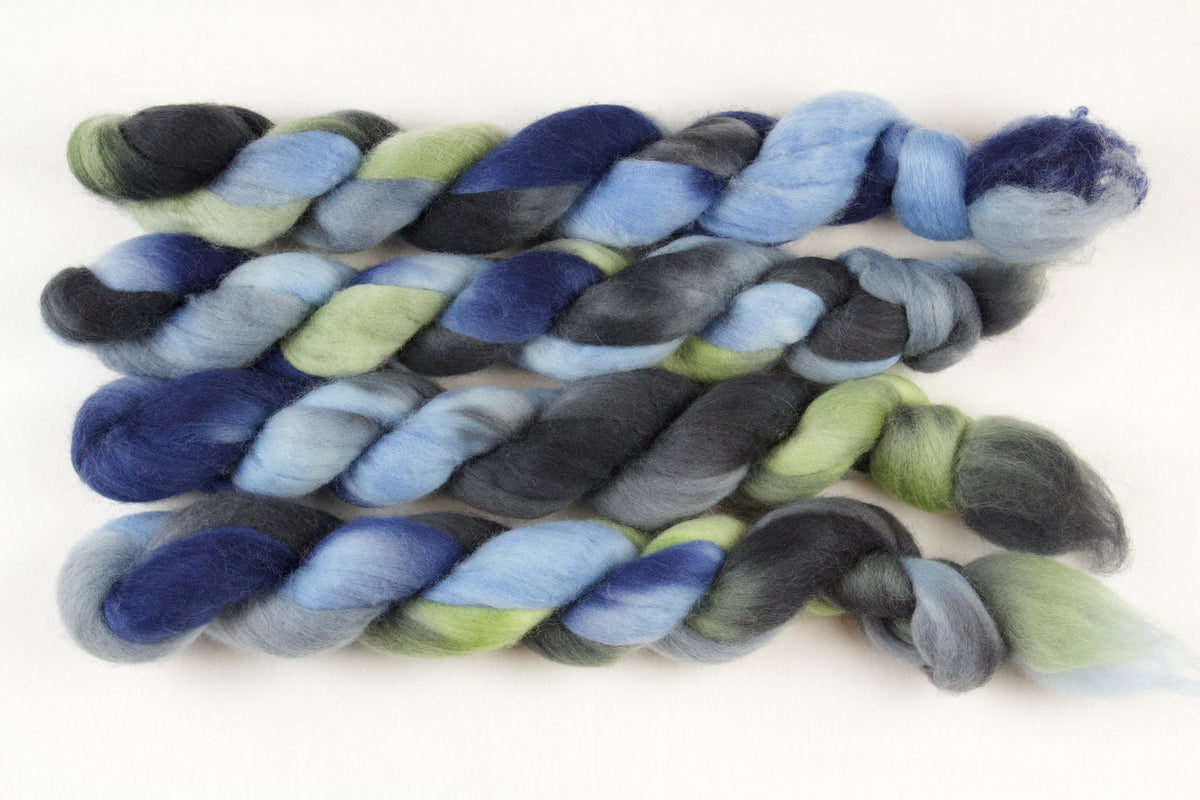 Braided fiber skein with blue, gray, and green on a white background