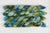 Braided fiber skein with green and blue gradient on a white background