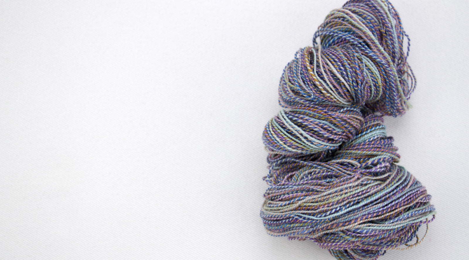 Multicolored skein of handspun yarn on a white background