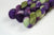 Braided fiber skein with purple and green on a white background