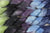 Braided fiber skein with blue, purple, black, and green on a white background