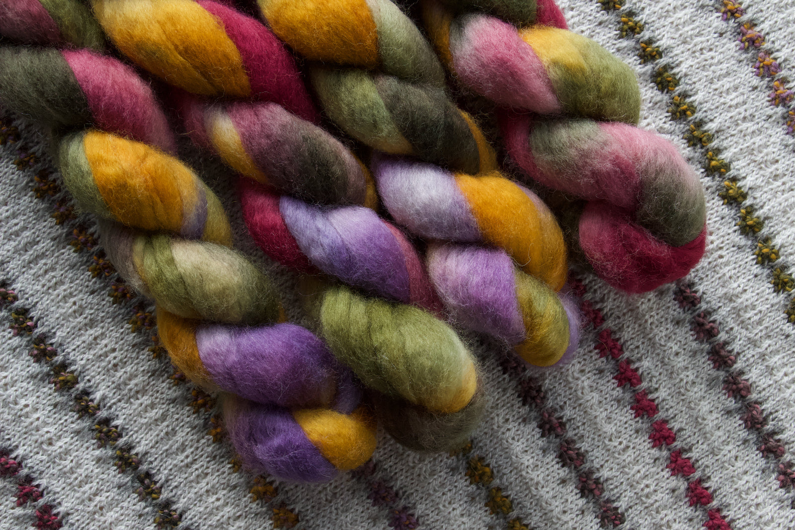 Multicolored fiber skeins on a knitted fabric background