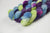 Braided fiber skein with blue, purple, pink, and green on a white background