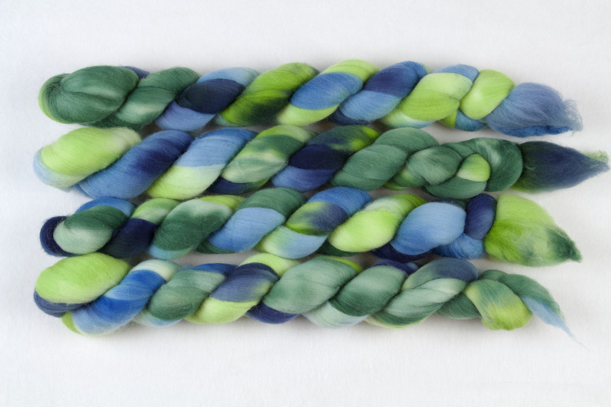 Braided fiber skein with green and blue on a white background