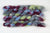 Braided fiber skein with blue, red, gray, and green on a white background