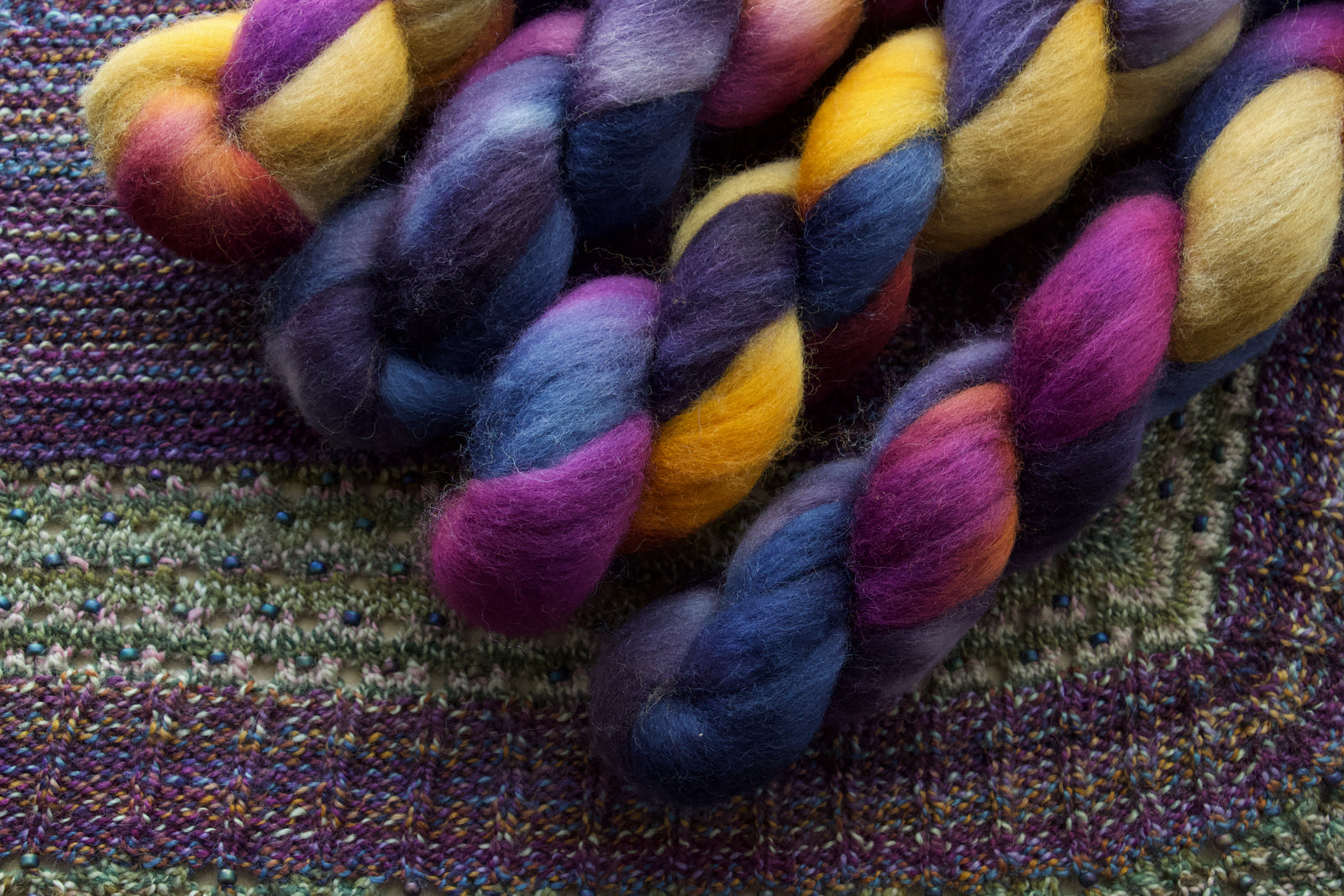 Colorful fiber skeins on a knitted fabric background